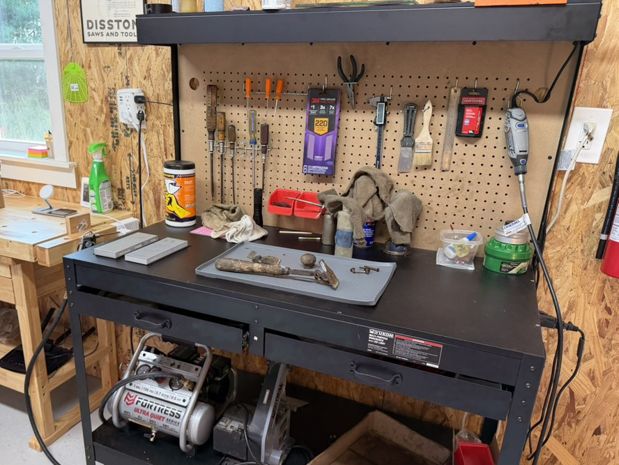 Vintage tool parts laid out for inspection on a workshop bench