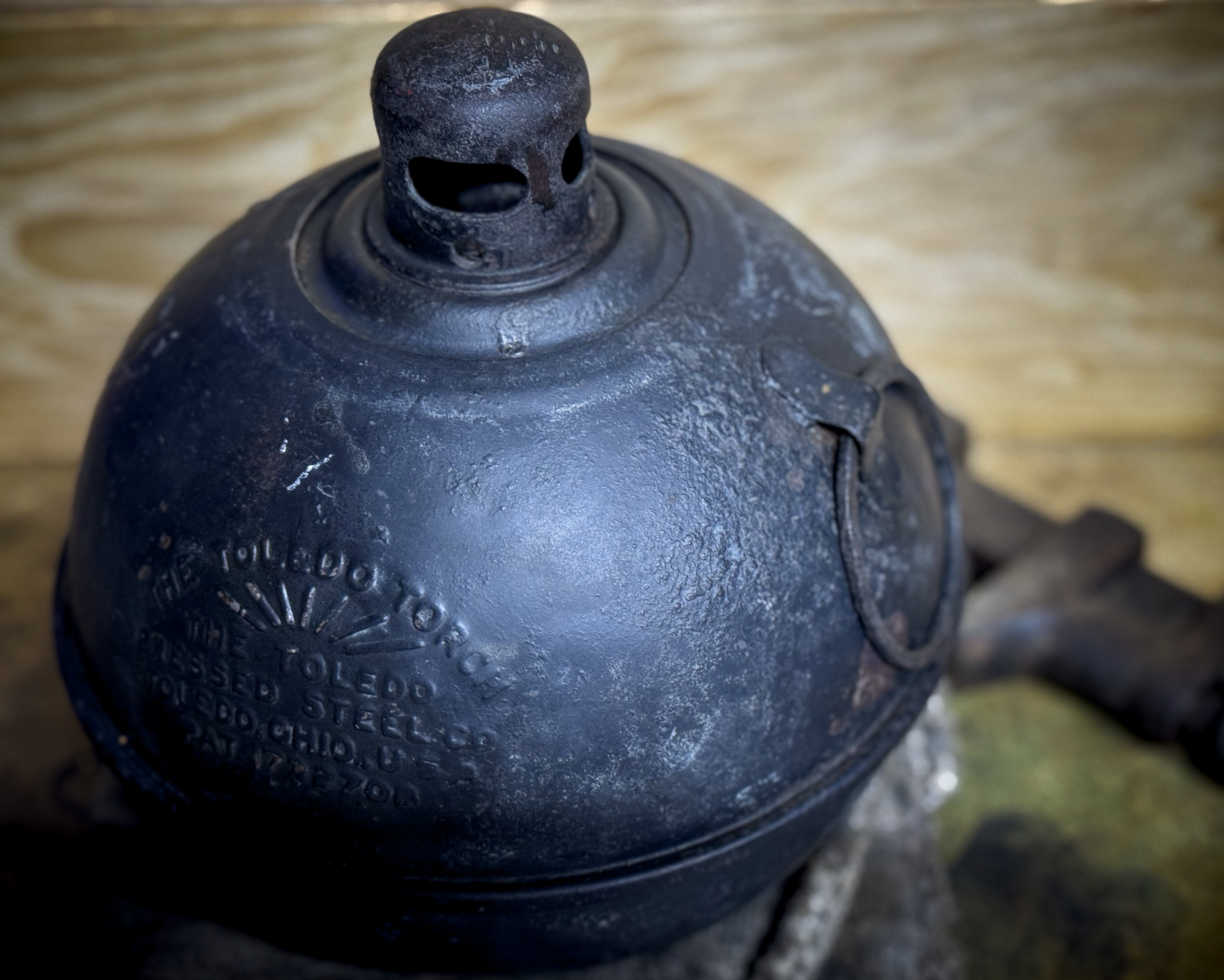 Close-up of a vintage Toledo kerosene road torch showing its original finish and embossed markings