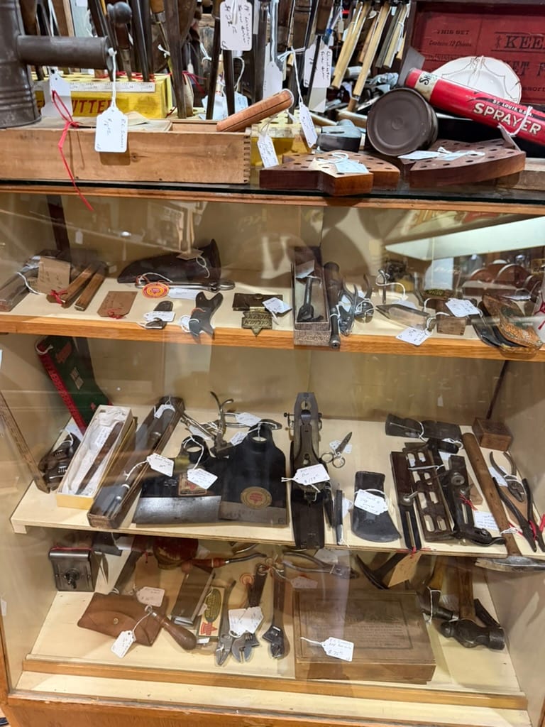 Display case filled with vintage Keen Kutter tools, packaging, advertising, and related material
