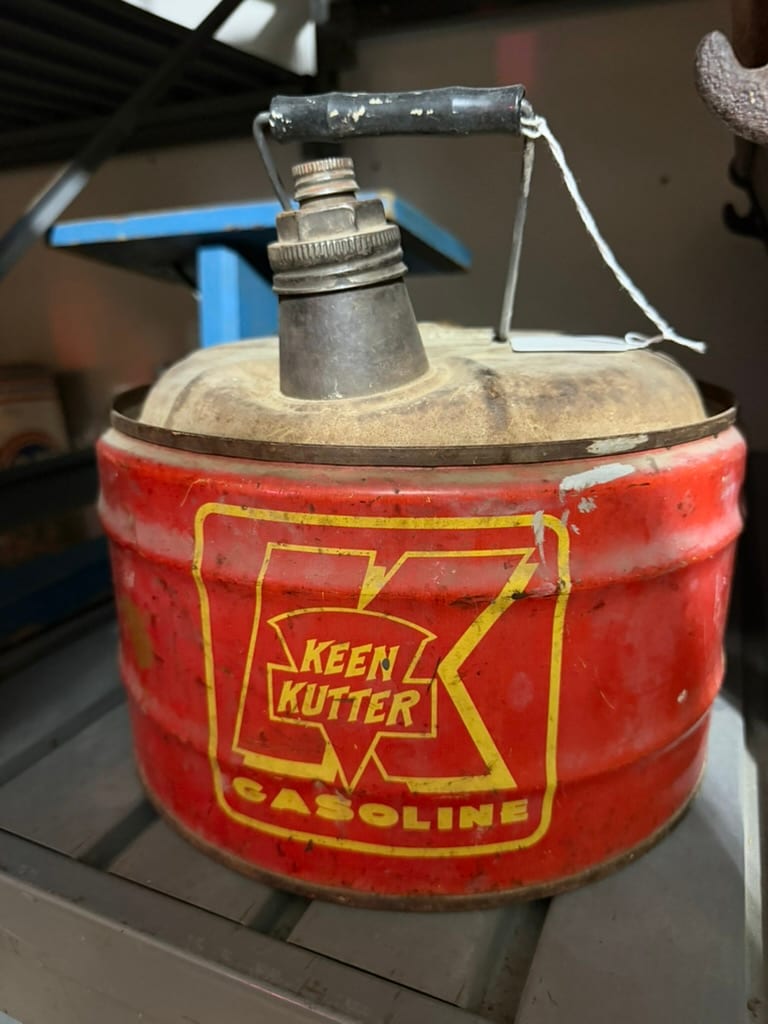 Large vintage Keen Kutter branded gasoline can displayed with other period hardware-store material