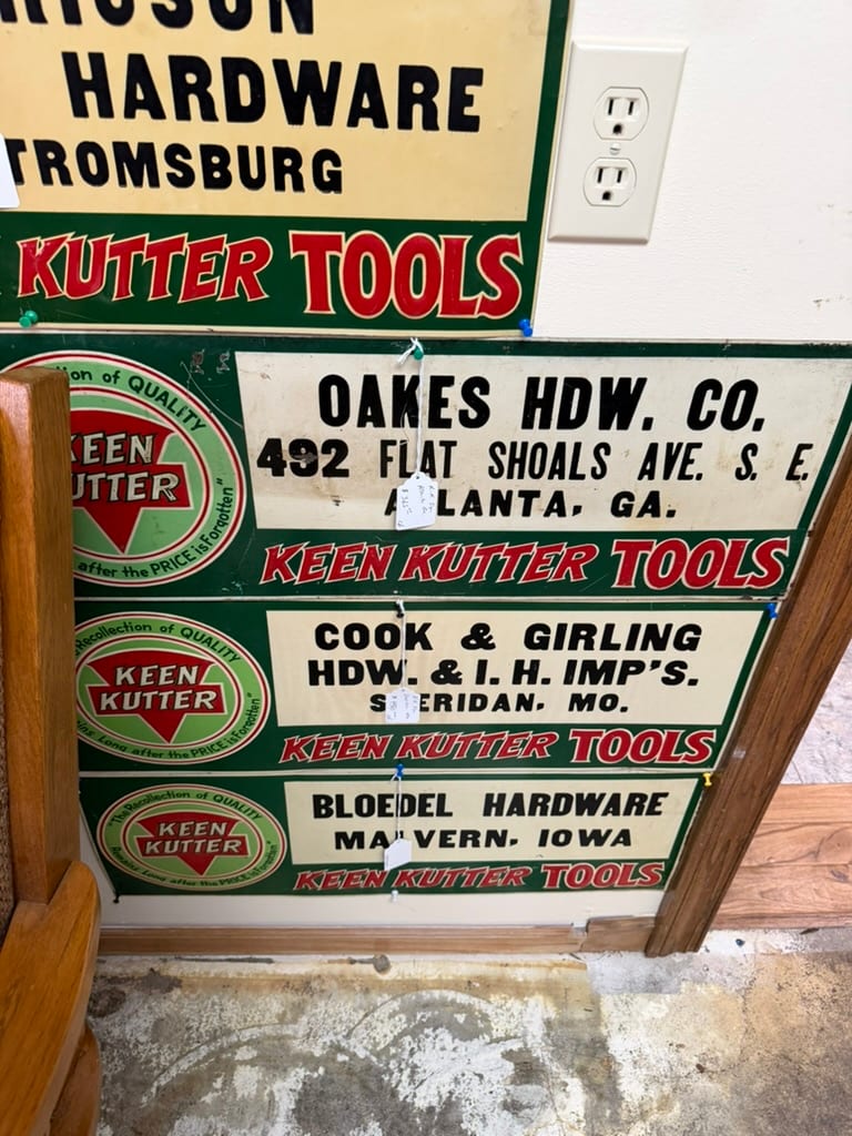 Group of green Keen Kutter dealer signs carrying the names of different hardware stores and towns