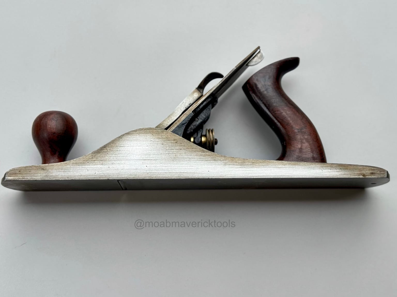 Side profile of a well-preserved restored Stanley Bailey No. 5 jack plane with clean metal, dark wood handles, and much of its original finish intact
