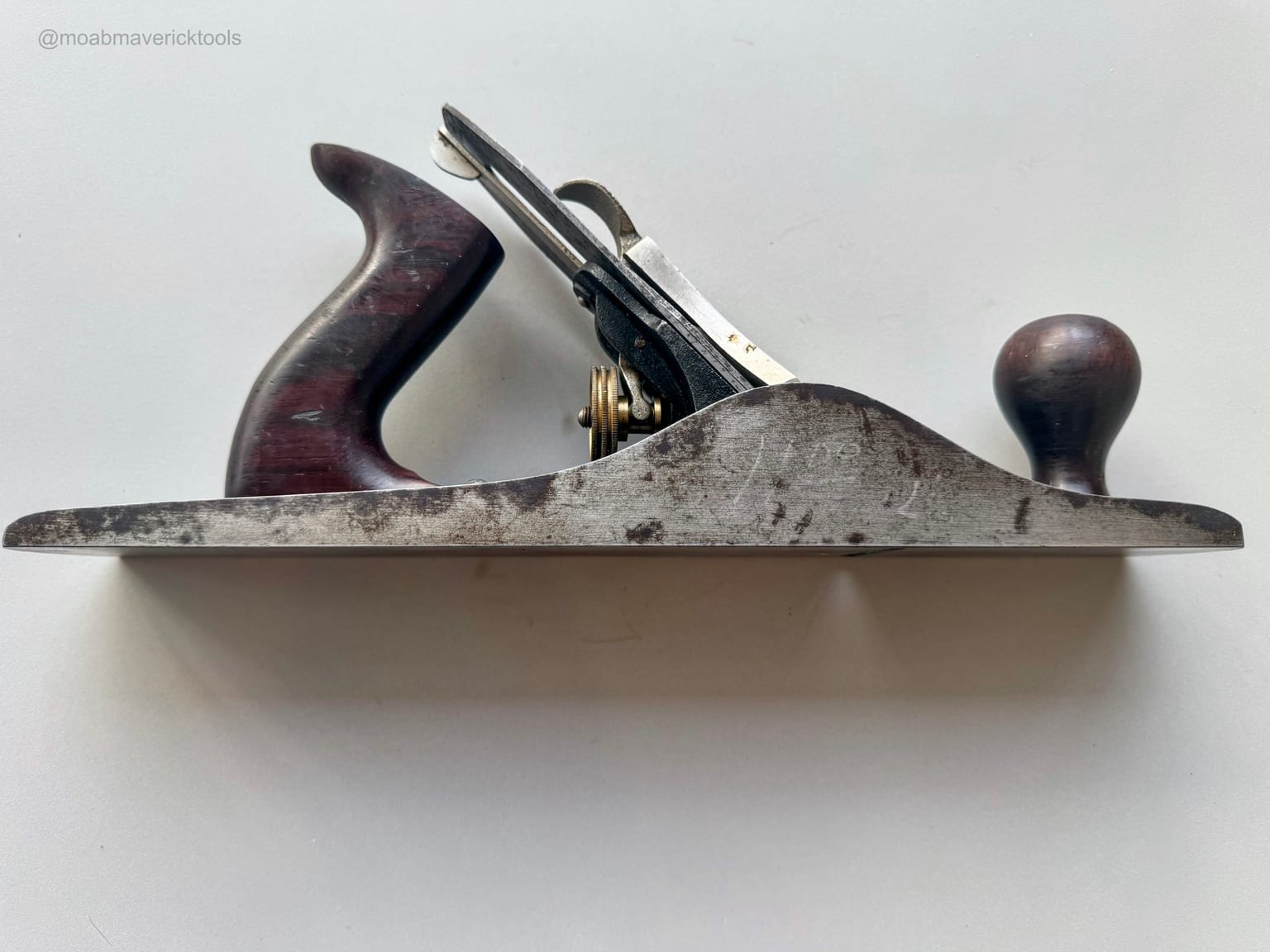Side profile of a restored Stanley Bailey No. 5 jack plane with visible staining, spotting, and age on the cheek and exposed metal