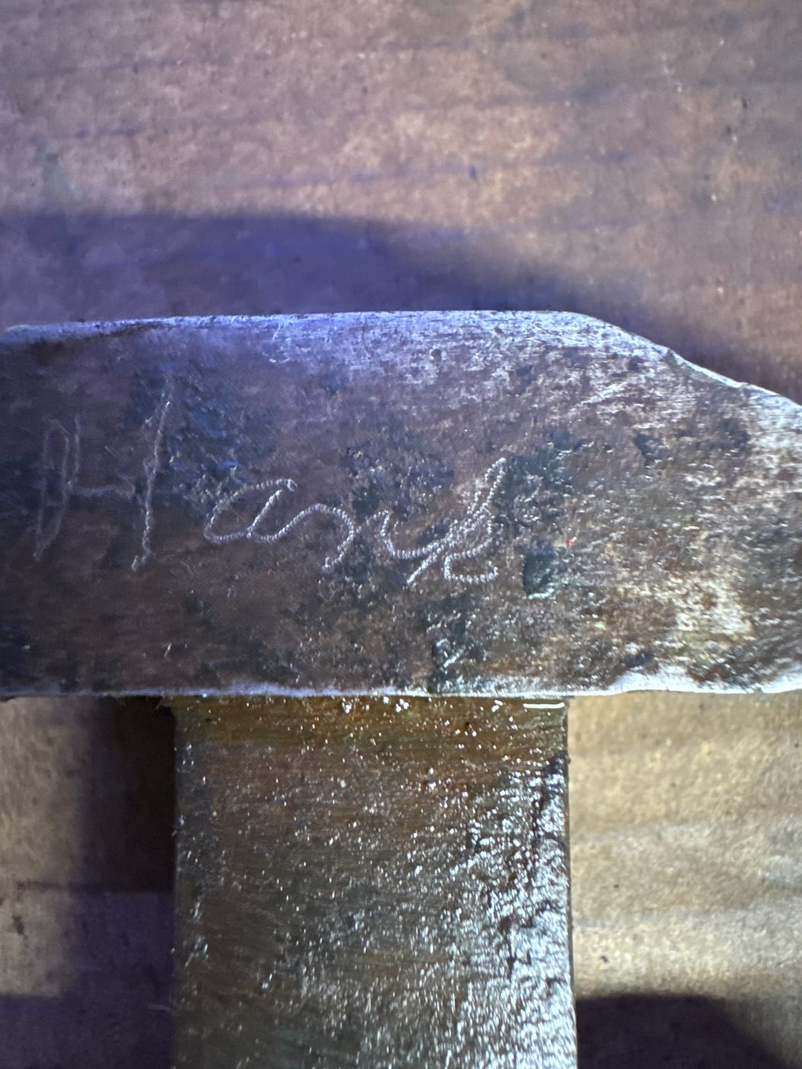 Hand-scribed name beginning to emerge on the jaw of an antique adjustable wrench during cleaning