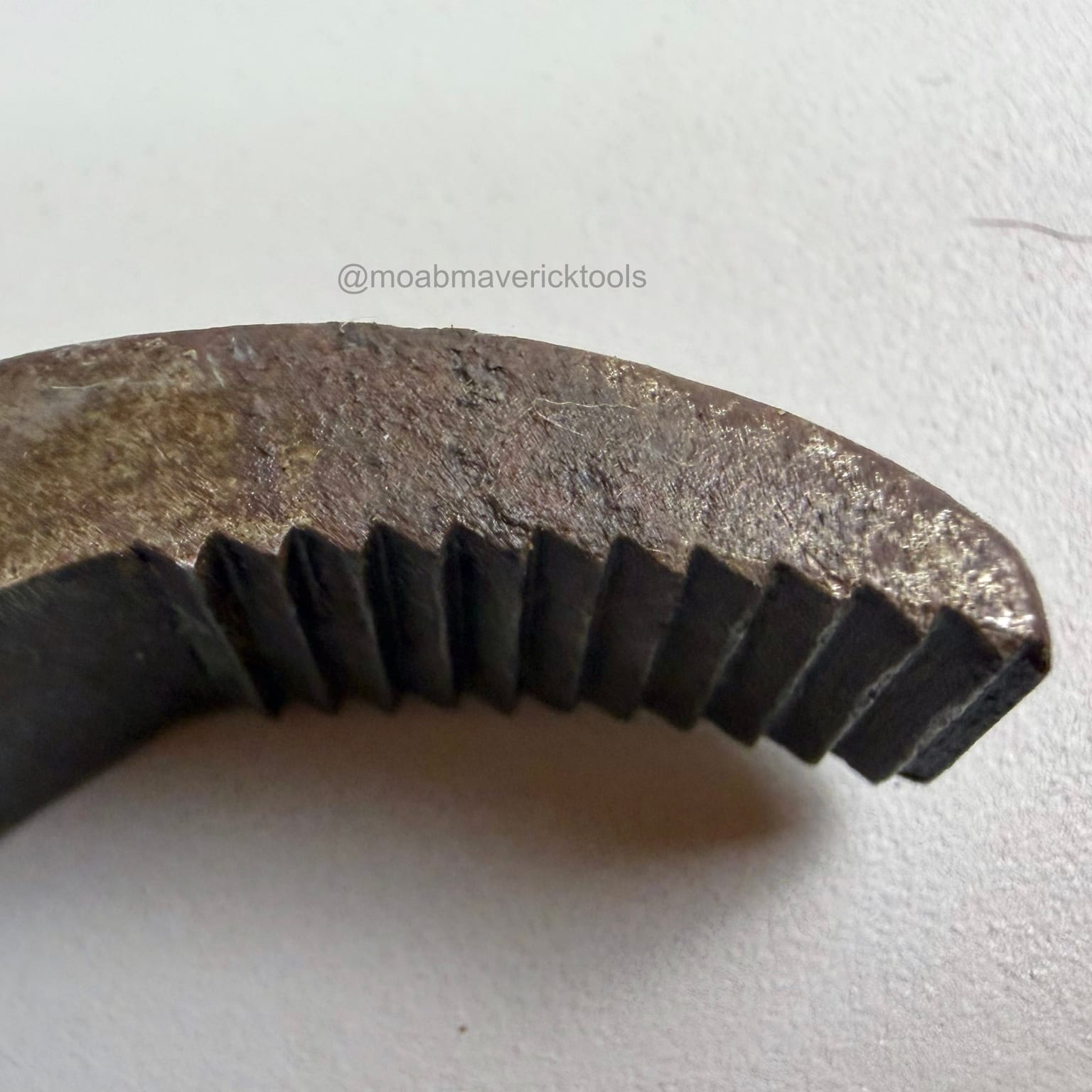 Close view of the curved serrated jaw on antique shoemaker lasting pliers