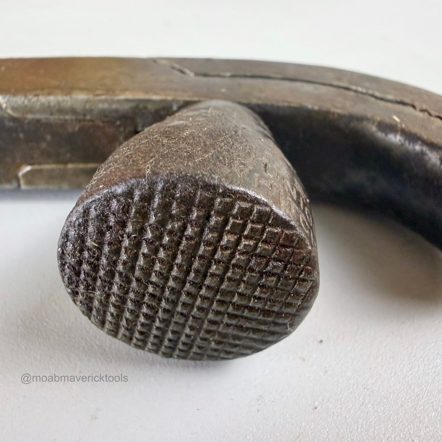 Close view of the crosshatched striking face on the integral hammer of antique lasting pliers