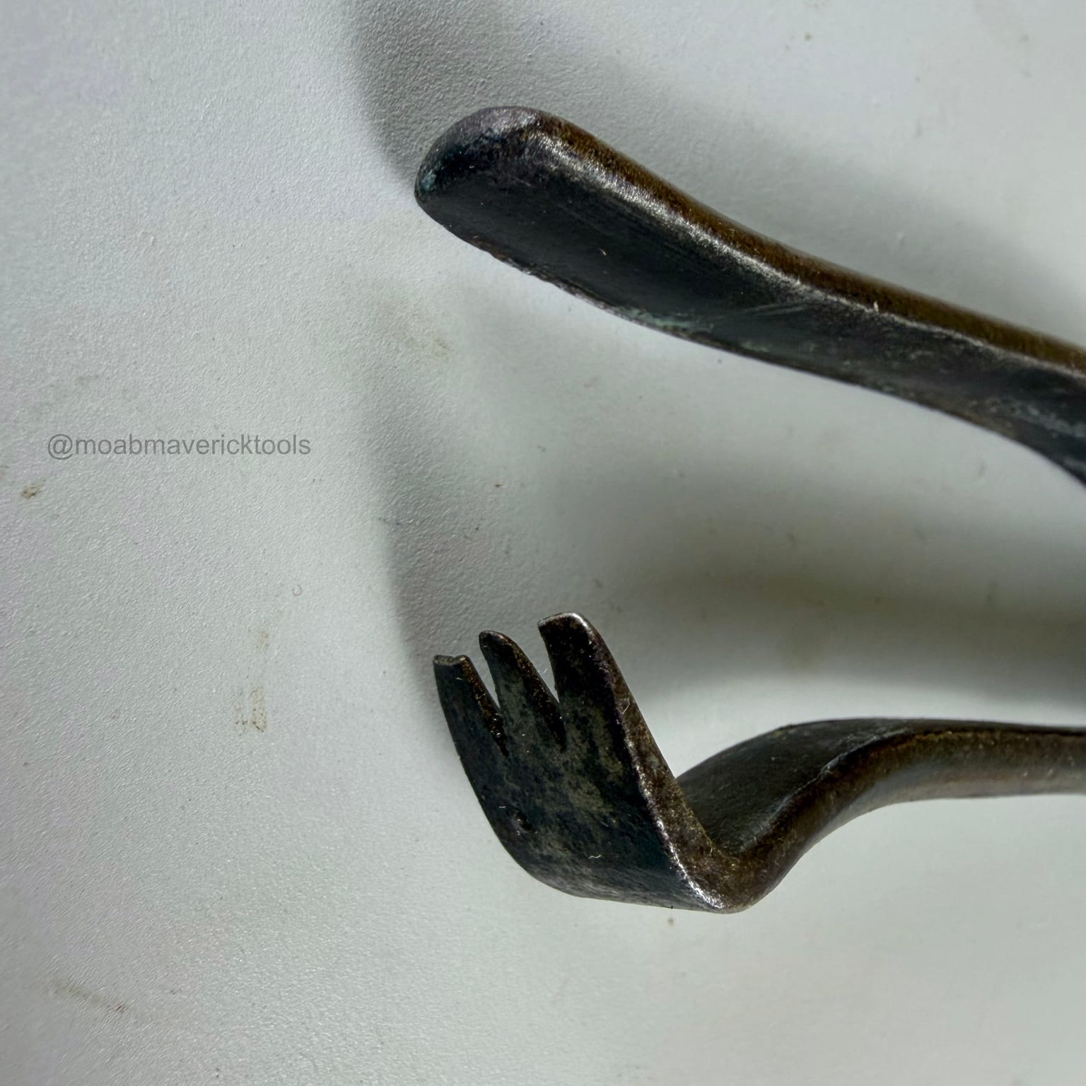 Close view of the three-tooth tack-pulling claw and plain opposing handle end on antique lasting pliers