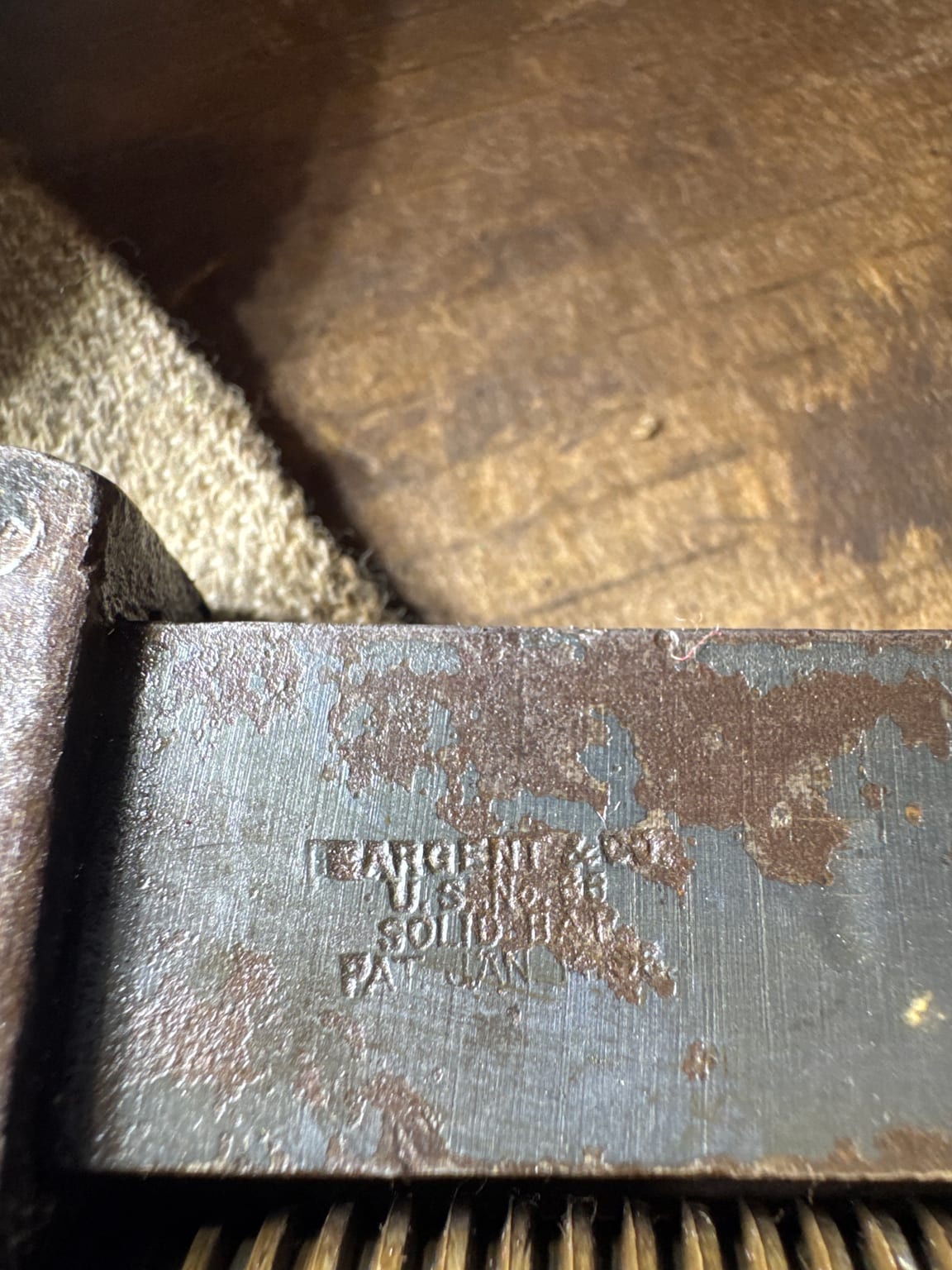 Partially exposed and difficult-to-read Sargent and Company factory stamp on an antique wrench