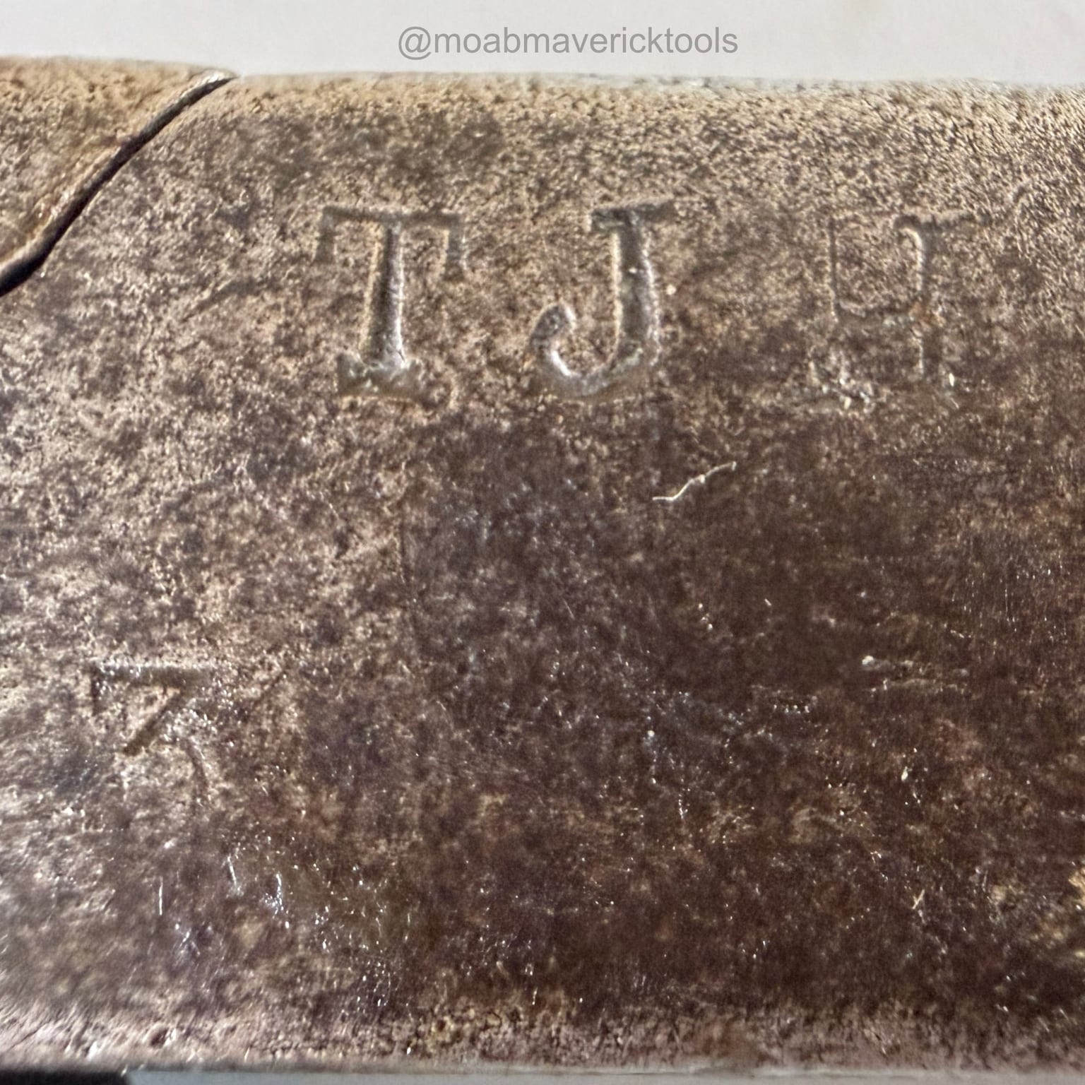 Close view of a deep TJ stamp and a fainter number 3 on antique Whitcher lasting pliers