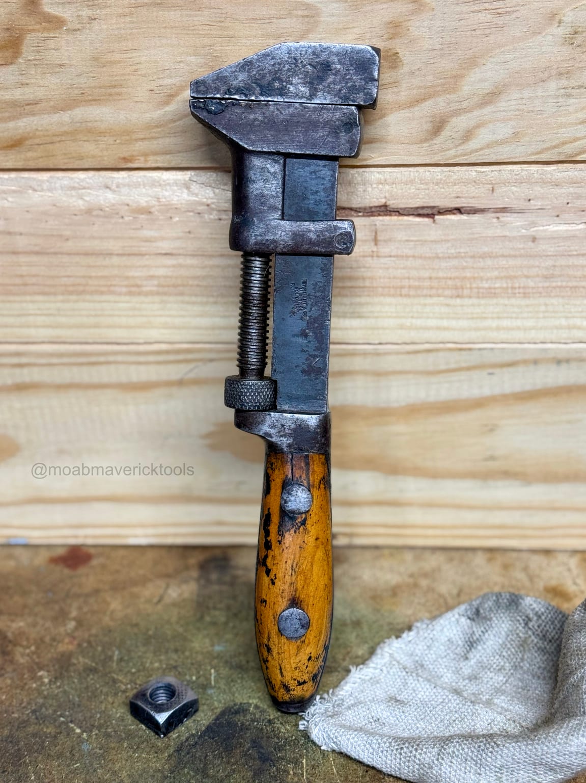 Restored Sargent No. 88 adjustable wrench standing on a workshop bench with original patina preserved